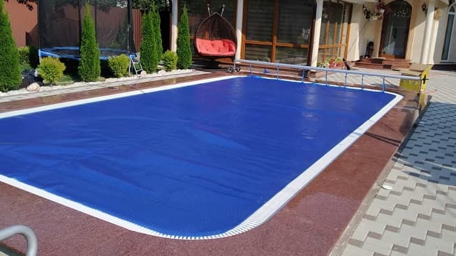 Residential swimming pool with cover and surrounding equipment area