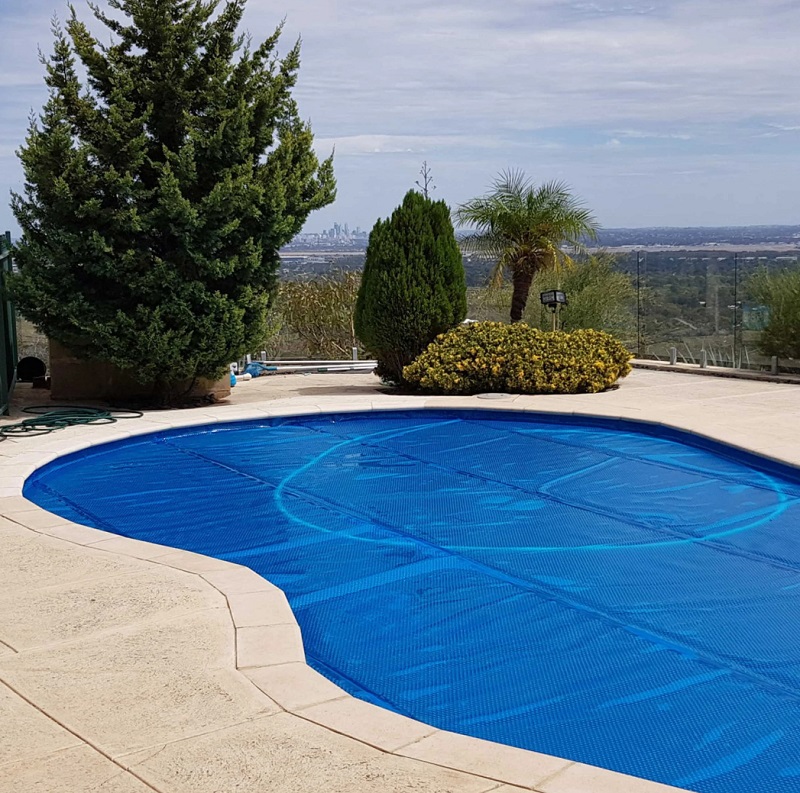 Pool blanket roller positioned near the pool edge